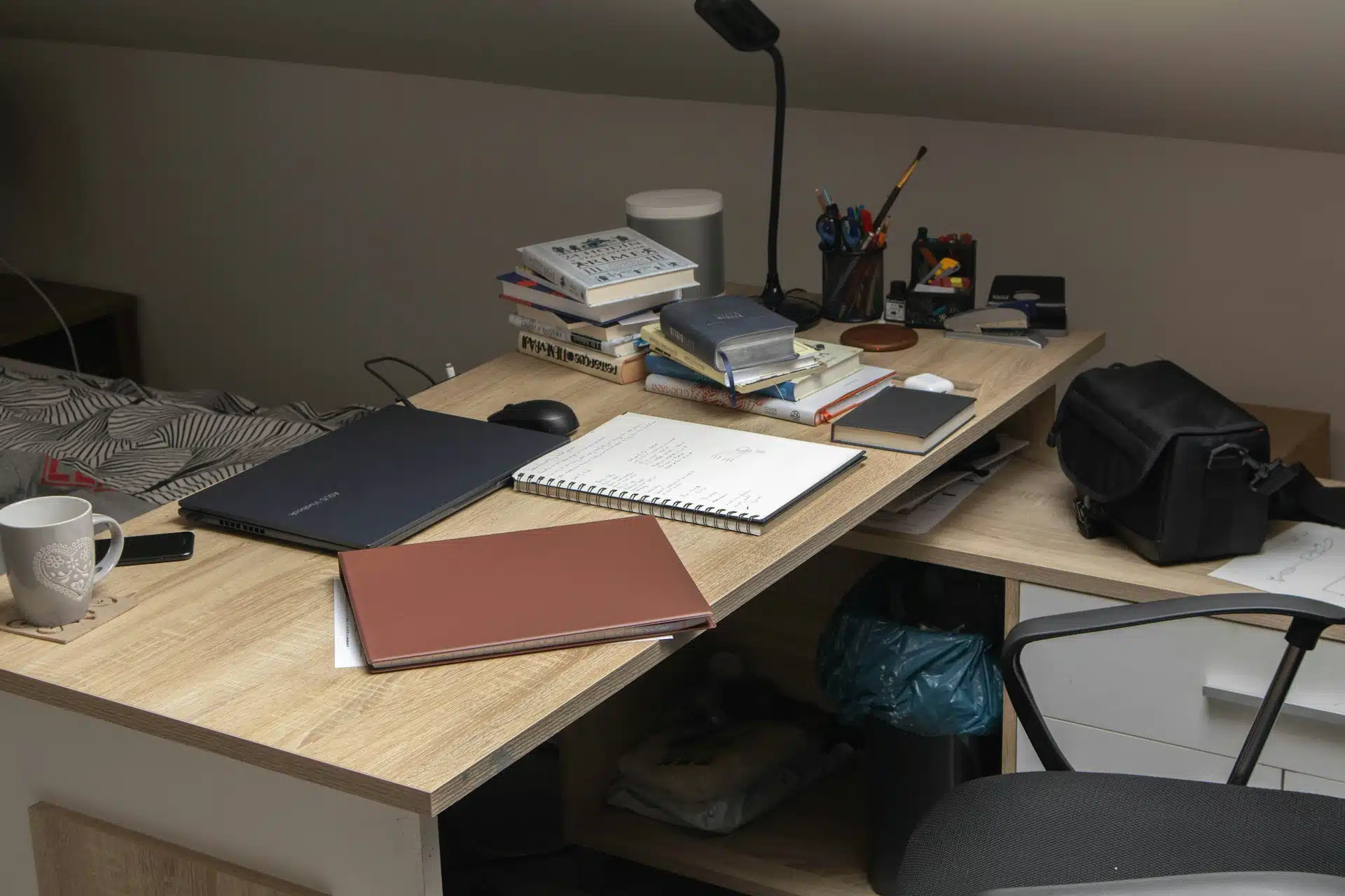 A wooden desk topped with a laptop computer A wooden desk topped with a laptop computer